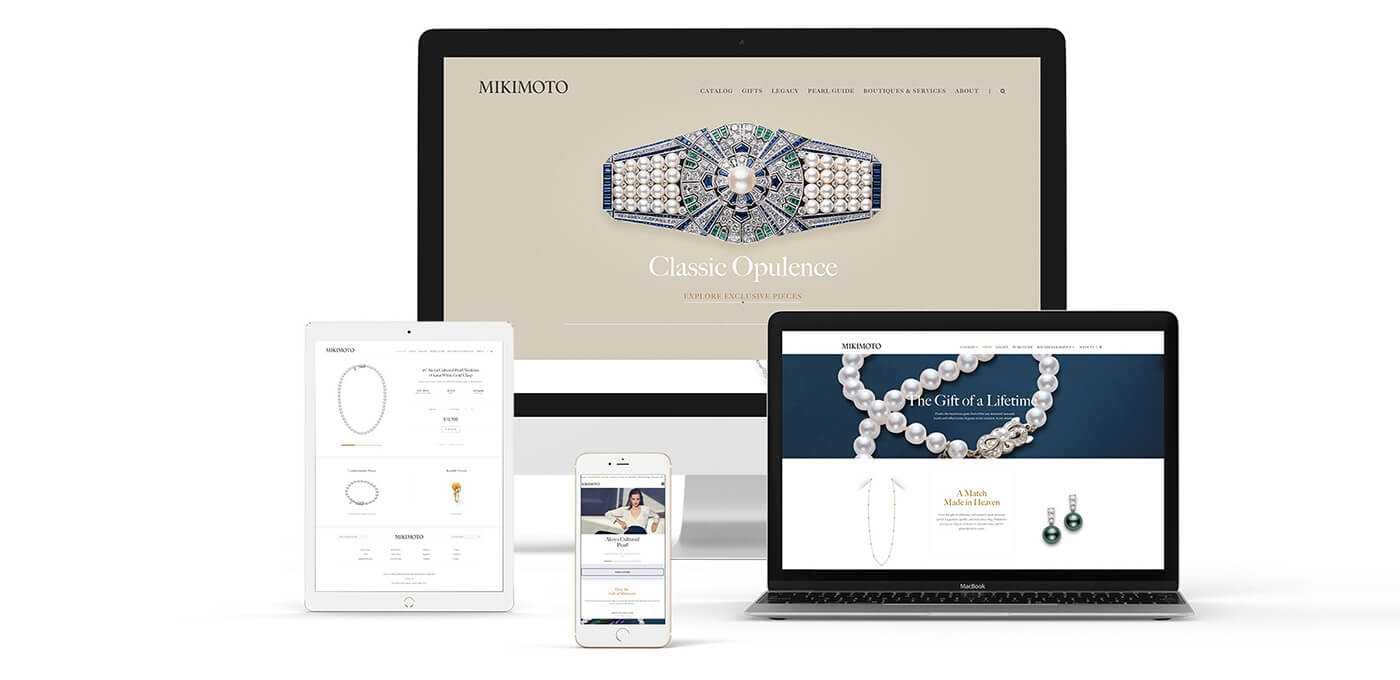 Desktop, laptop, tablet, and phone showing a jewelry website with a jeweled belt on beige and a pearl necklace on navy.