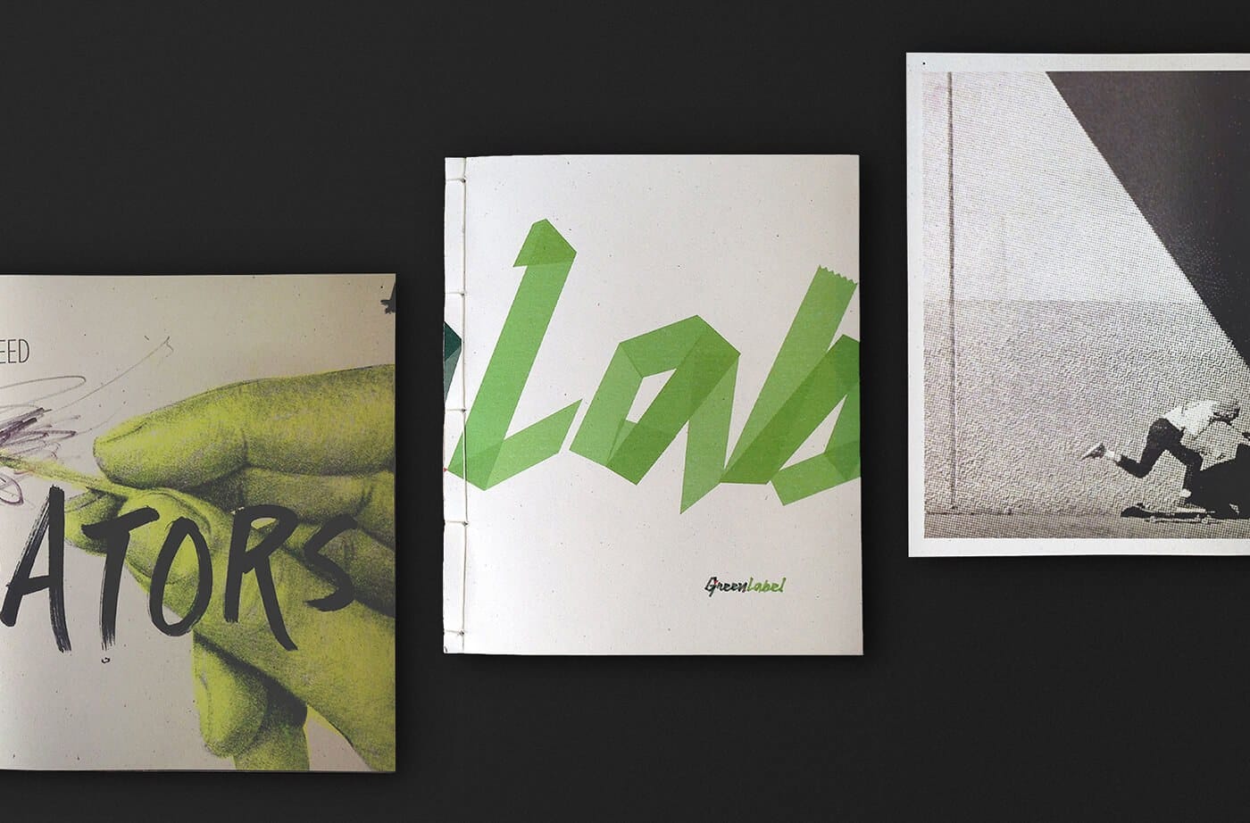 Three art zines on a dark surface: left shows a green hand and the partial ATORS text, center white cover with lime geometric letters, right grayscale image of a person near a triangle.