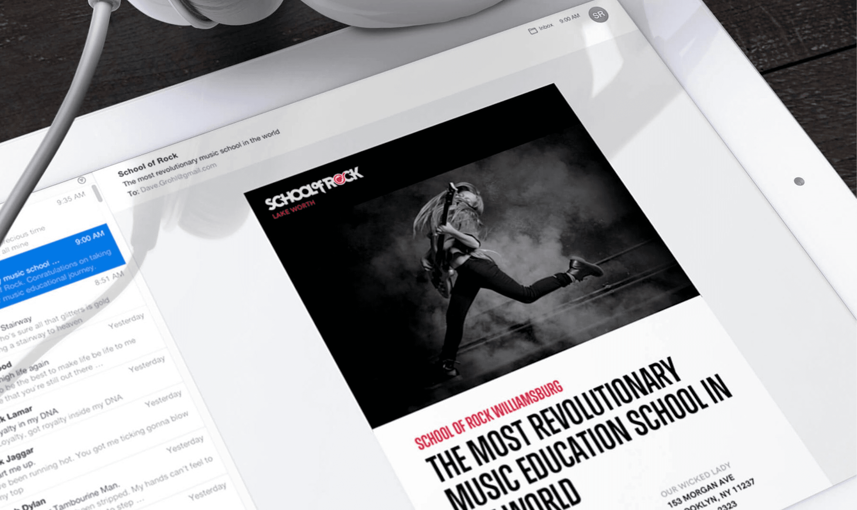 Tablet on a white desk with headphones; screen displays a black-and-white School of Rock poster of a musician jumping with a guitar and slogan.