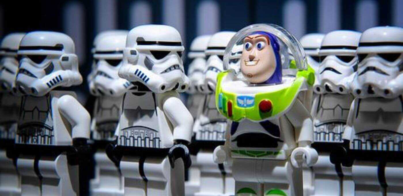 LEGO space ranger with a bright green chest plate and clear helmet stands among many white Stormtrooper minifigures.