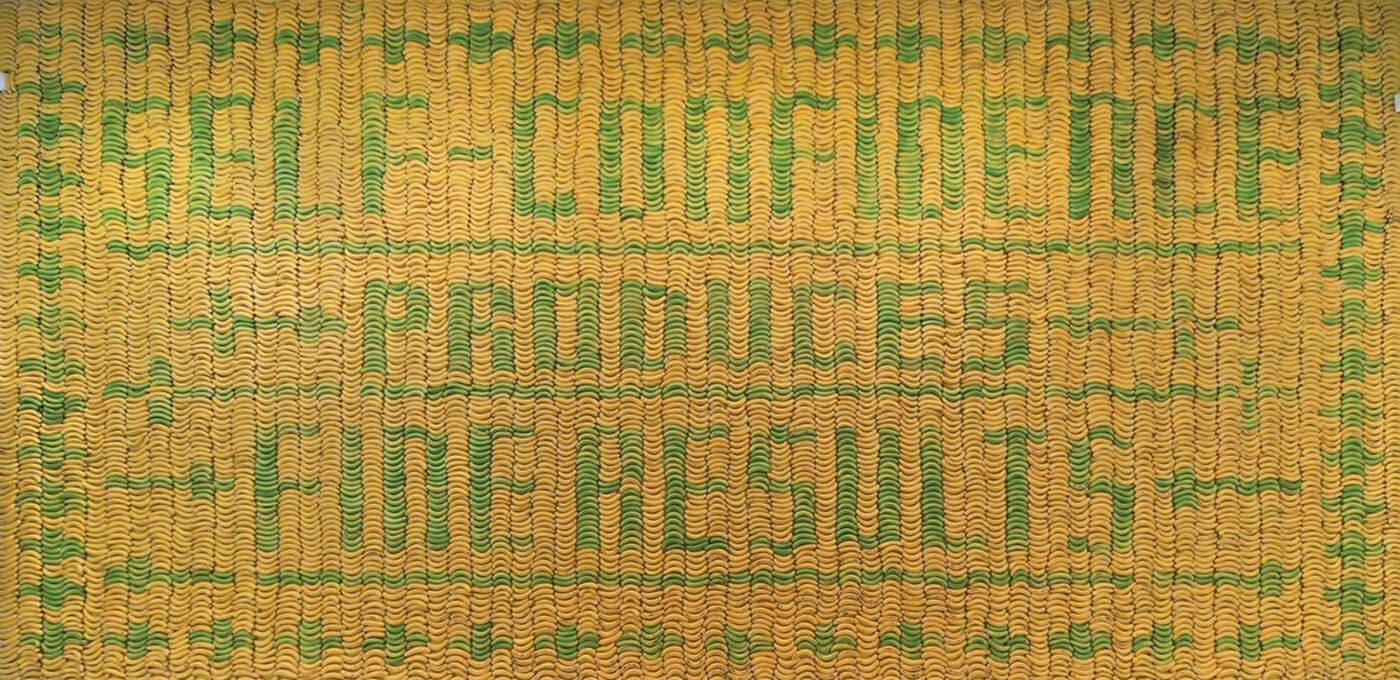 Close-up of a yellow and green woven mat with bold green letters forming words across the surface.